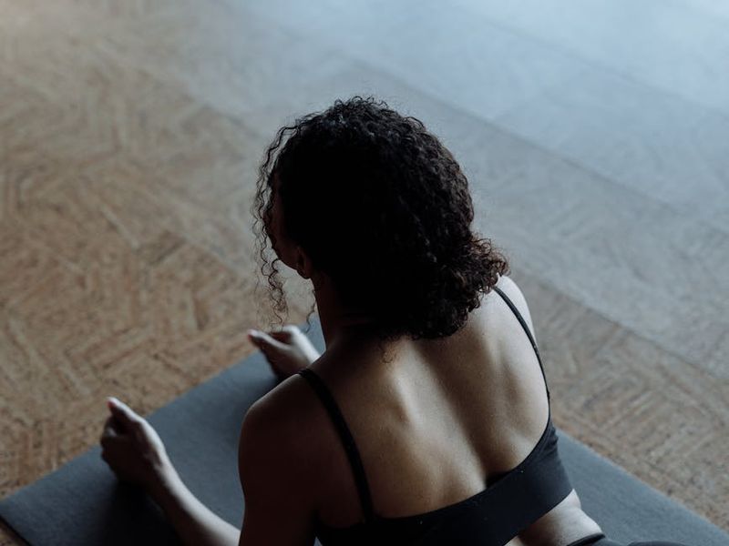 Wide view of a dark minimalist yoga studio with mats.